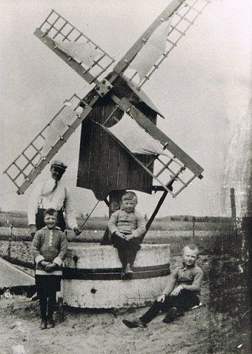 vlnr Met pet Martin Martens [knecht] - Rein Jetten - Toon Jetten zittend op molensteen - zittend Jan Jetten. foto genomen 1933 bron T.Jetten
